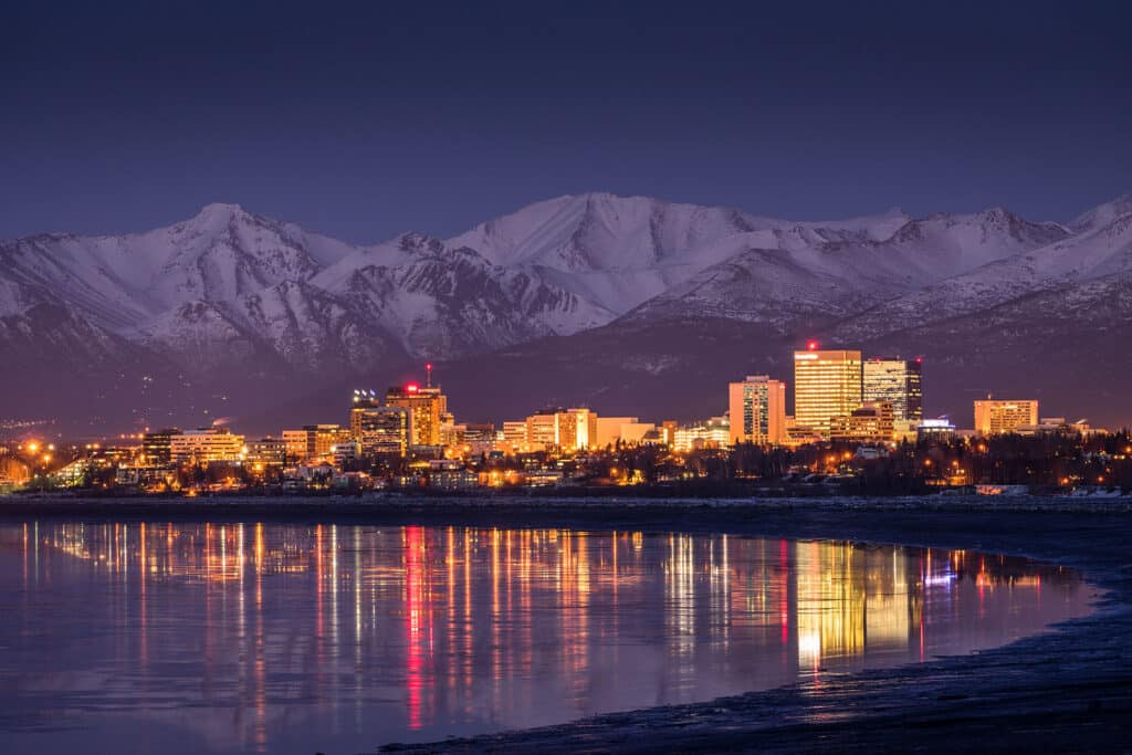 Anchorage city lights reflecting on Cook Inlet at twilight